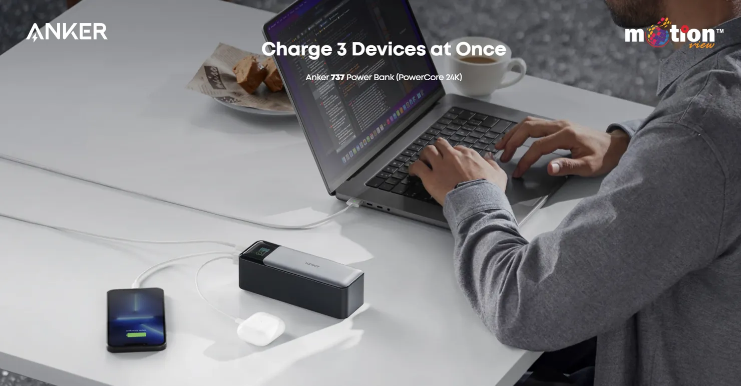 User working at a desk while simultaneously charging a laptop, smartphone, and wireless earbuds with the Anker 737 PowerCore 24K
