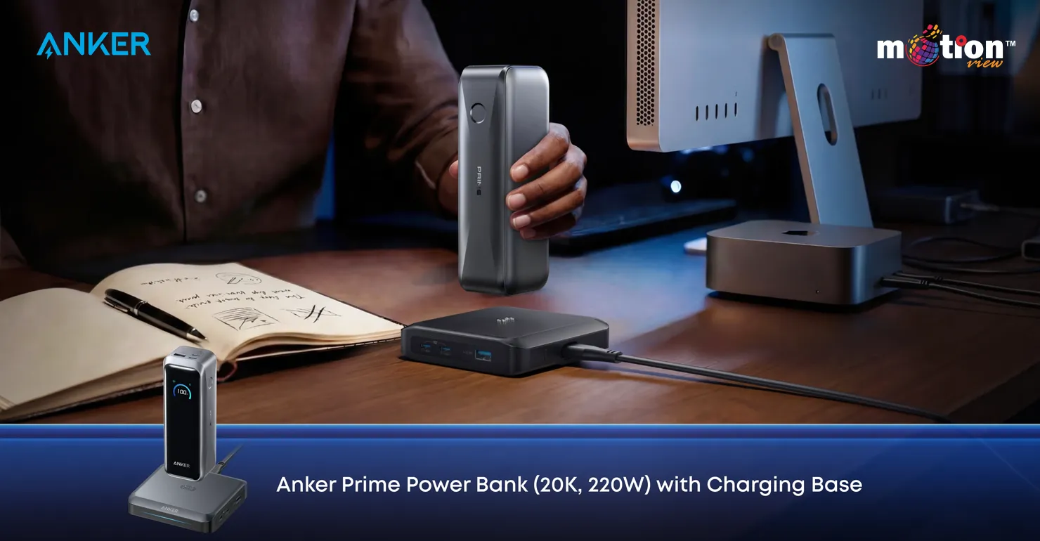 A user lifting the Anker Prime 20K 220W Power Bank from its dedicated charging base on a modern wooden office desk setup