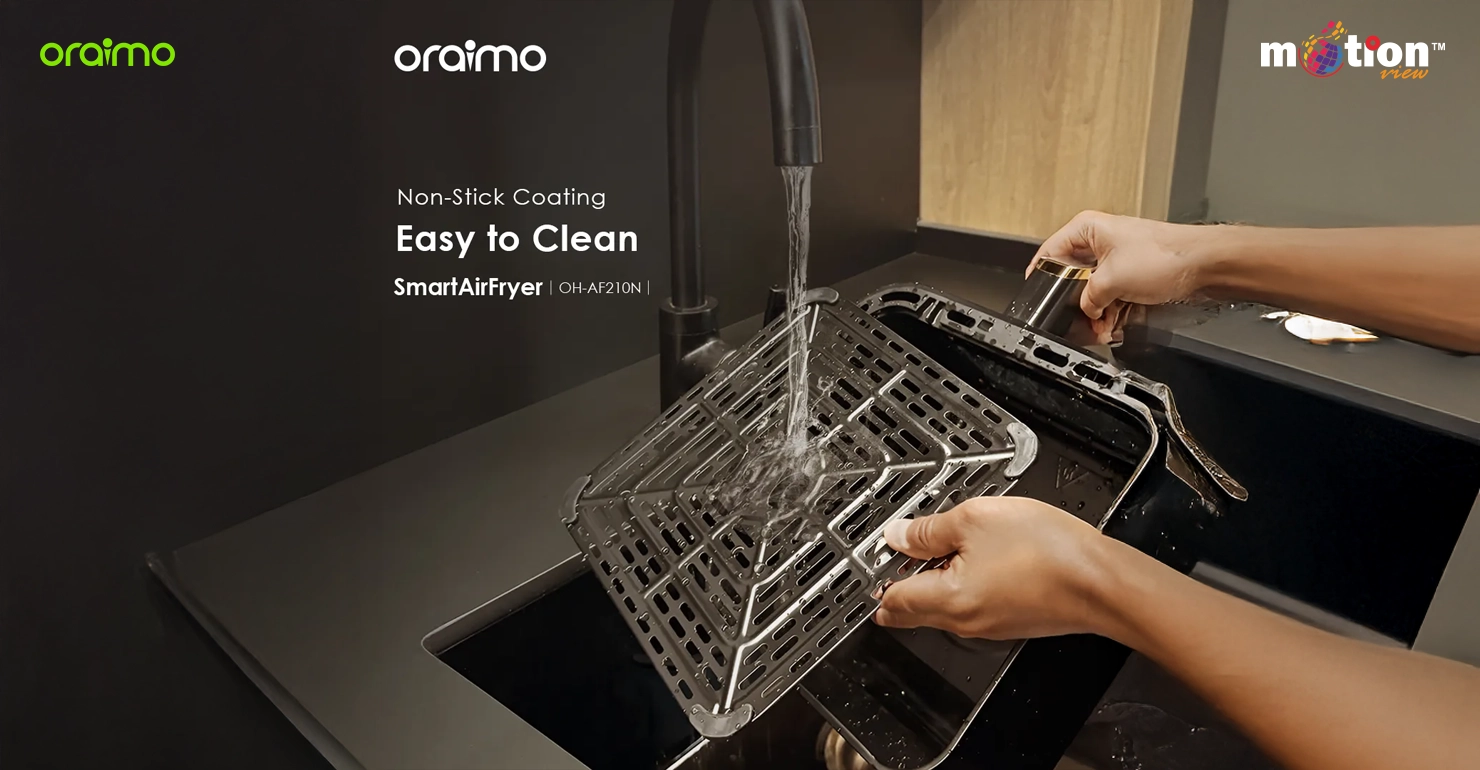 Non-stick coating tray of the Oraimo 5L SmartAirFryer being washed under a tap to show easy-to-clean features.