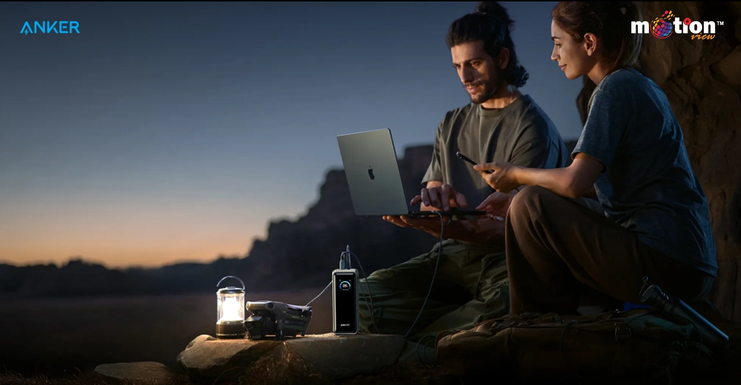 Professional photographer using the Anker Prime 26K 300W power bank to charge camera gear during an outdoor shoot.
