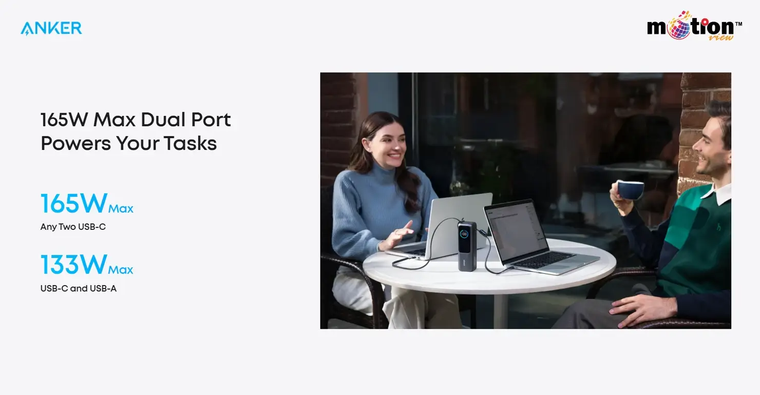Two professionals working at an outdoor cafe with laptops connected to an Anker power bank delivering 165W max dual-port power.