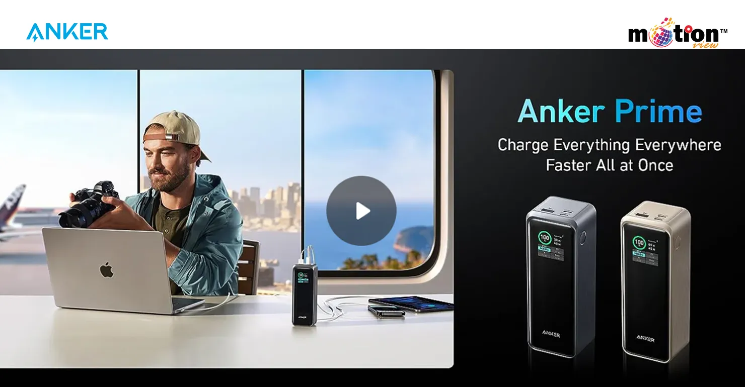 A traveler in an airport lounge using the Anker Prime 27K 250W Power Bank to simultaneously fast charge a MacBook, camera, and smartphone